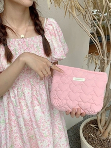Pink heart quilted storage bag with Sezakka label held by a model in floral dress