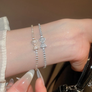 Close-up of gold and silver bow knot bracelets with sparkling cubic zirconia stones