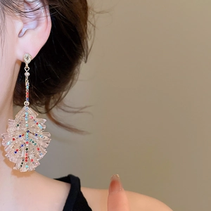 Detail of Christmas tree drop earring with crystals on long gold chain and pink resin