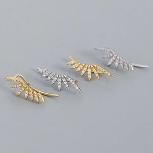 Detailed view of silver and gold wing ear cuffs with micro-set sparkling zircon stones
