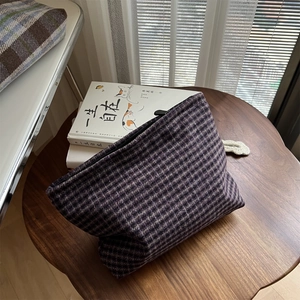 Detailed view of dark purple houndstooth tweed cosmetic bag with premium zipper closure