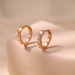 Macro shot of 18K gold plated hoop earrings featuring baguette-cut zircon stones