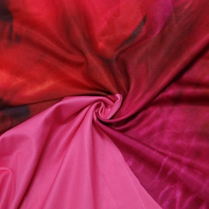 Detailed macro view of red and pink tie-dye pattern on smooth synthetic fabric