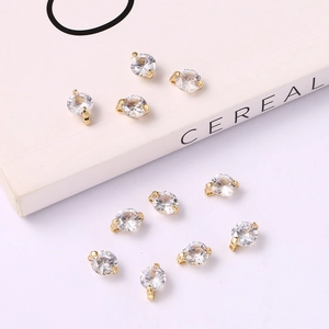 Flat lay of gold round charms with sparkling cubic zirconia on a white background