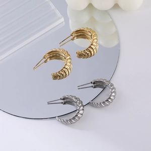 Détails des boucles d'oreilles croissant en C dorées et argentées sur verre poli