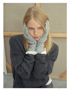 Close-up of grey 35% wool blend touchscreen gloves worn by a model in a soft setting