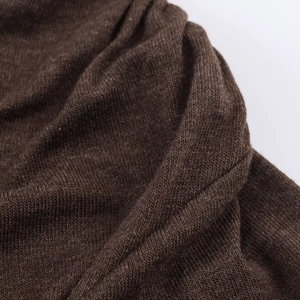 Close-up of dark brown knitted fabric texture showing soft pleats and material detail