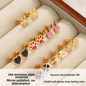Détails macro de boucles d'oreilles en acier titane 304 aux motifs trèfle et animaux