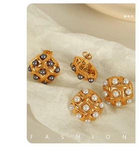 Detailed view of woven grid titanium earrings with grey and white pearls in gold setting