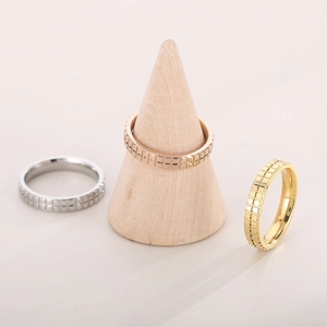 Three-color grid pattern 18k gold plated stainless steel rings displayed on wooden stand
