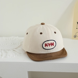 Close-up of baby baseball cap with KYM letter embroidery and contrast brown soft brim
