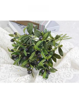 Close-up of artificial olive branches with green leaves and realistic dark fruits