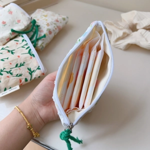 Detail of floral cotton coin purse showing interior capacity and soft green zipper pull