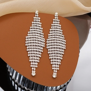 Macro detail of silver tassel earrings with geometric rhinestone mesh design