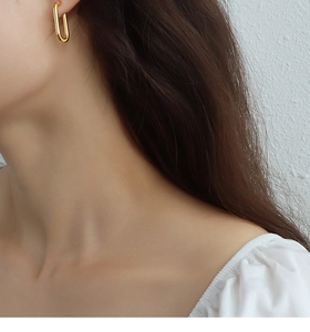 Primo piano di una modella che indossa orecchini a cerchio dorati a forma di U