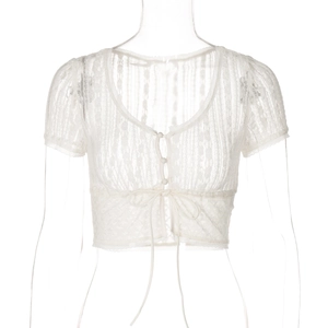 Dettaglio del cardigan corto in pizzo bianco con scollo a V, bottoni e fiocco da annodare