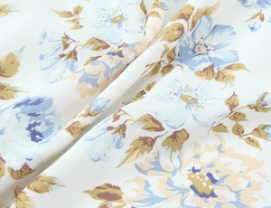 Makroaufnahme von leichtem Chiffon-Stoff mit zartem blau-beige Blumenmuster-Detail