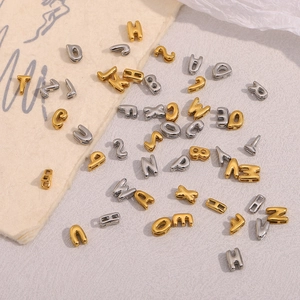 Vue macro de perles de lettres évidées dorées et argentées sur un fond texturé
