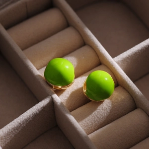 Detail of round lime green enamel ball earrings with elegant gold plated finish