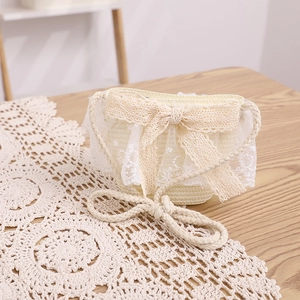 Detail of hand-woven straw bag with elegant lace bow and rustic hemp rope strap