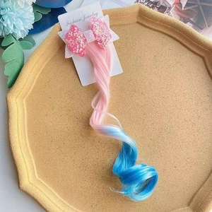 Kids gradient bow hair clip with pink to blue sequin wavy hair extensions on tray