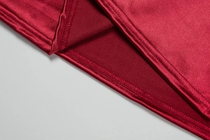Detailed macro view of red satin fabric showing high-quality stitching and hem finish