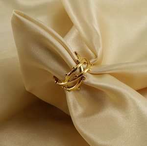Macro shot of 18K gold-plated double-layered geometric ring on elegant champagne silk