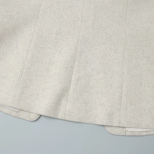 Close-up of oatmeal beige linen blend hem showing high-quality stitching and fabric texture