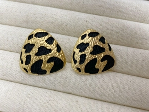 Macro shot of triangle leopard print studs with golden alloy base on jewelry box