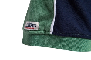 Detail of green and blue color-block polo shirt hem with textured pique cotton fabric