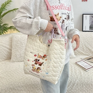 Close-up of white heart quilted tote bag with cute cartoon dogs and purple braided handle