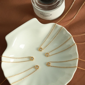Gold stainless steel hexagonal pendant necklace with zircon stone on white shell tray