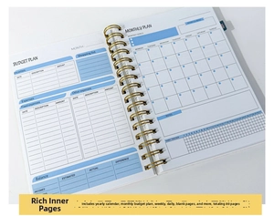 Detail of spiral bound budget planner showing monthly plan pages and habit tracker
