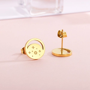 Detail of gold star and sun stud earrings with secure butterfly backings on pink surface