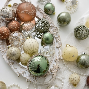 Bolas de Navidad en tono champán con acabados mixtos en una bandeja blanca vintage