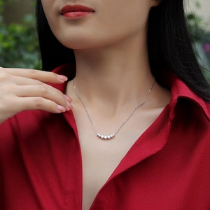 Minimalist S925 sterling silver moissanite necklace shown on a model with red shirt