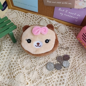 Plush brown bear coin purse with pink bow charm shown in a cozy miniature setting