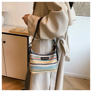 Detail of colorful striped woven shoulder bag with black leather strap and buckle