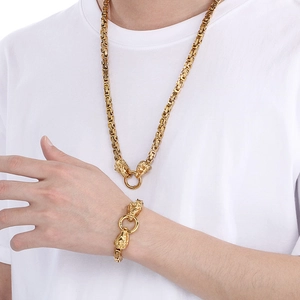 Detail of gold hip-hop lion head necklace and bracelet set on a male model with white shirt