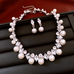 Detailed close-up of vintage pearl and diamond jewelry set in a black velvet display box