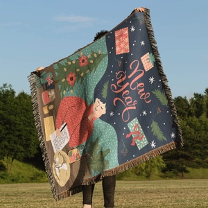 Detail of bohemian knit Christmas tree blanket with New Year illustration and tassel edges