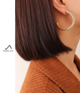 Detailed view of 18K gold plated C-shaped hoop earrings with sparkling white stones