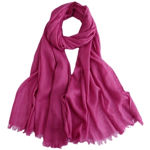 Vibrant rose red cotton linen scarf with soft fringe edges on a white background