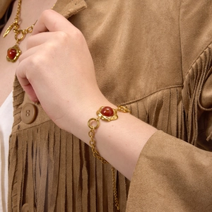 Bohemian gold stainless steel bracelet with red agate stone on model wearing suede