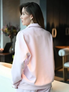 Detail view of pink fleece sweatshirt showing the ribbed hem and soft knit texture