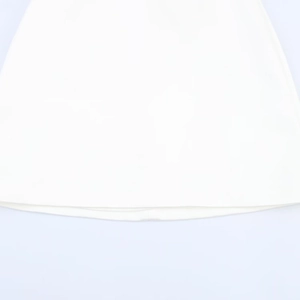 Detailed view of the white dress hem stitching and high-quality fabric texture