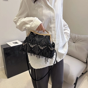 Detailed view of a black sequined shell bag with fringe and gold metal handle