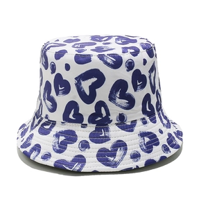 Detailed view of a white bucket hat featuring blue heart patterns on twill cotton fabric