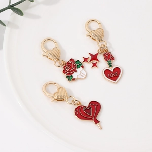 Golden heart and rose enamel keychain set with LOVE engraving in a ceramic bowl