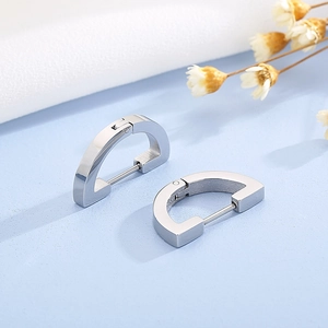 Detailed view of silver D-shape geometric earrings with a polished metallic finish